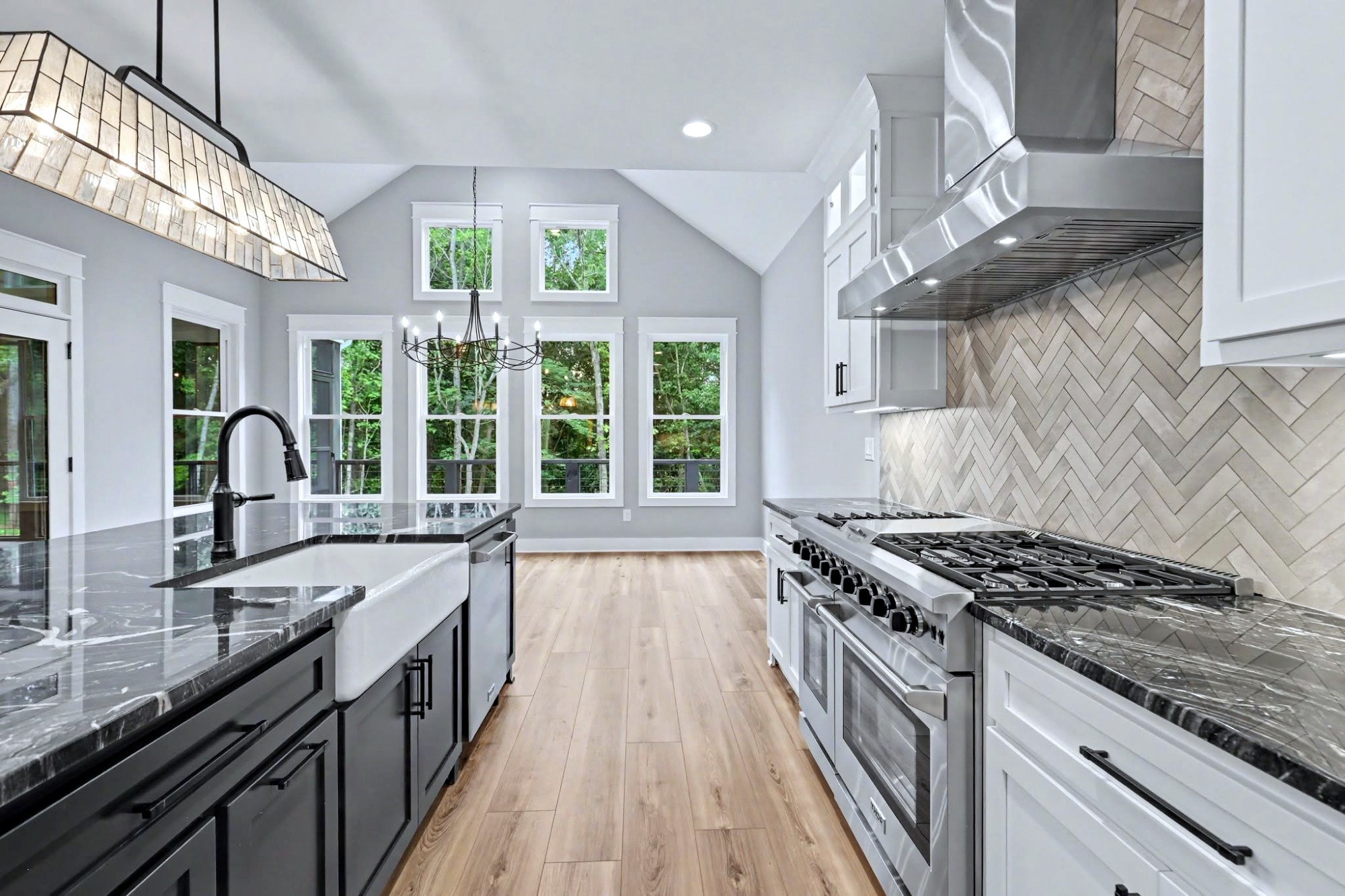 Makalu granite counters with a farmhouse sink and herringbone backsplash